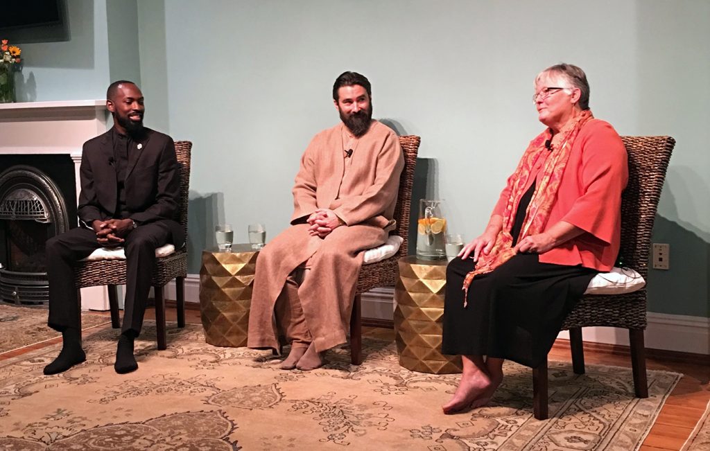 Spiritual leader Pir Zia Inayat-Khan sits with guest presenters at an event.