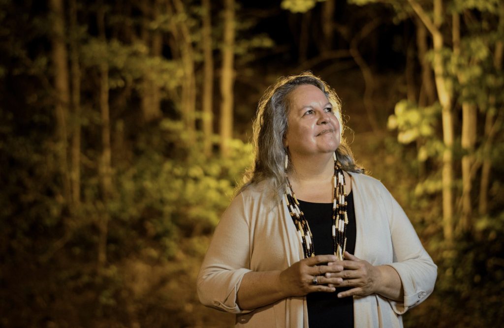 Image of Robin Wall Kimmerer standing in a forest