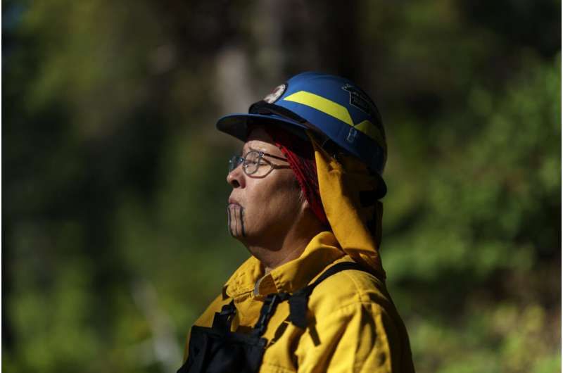 Woman tribal firefighter in prayer.