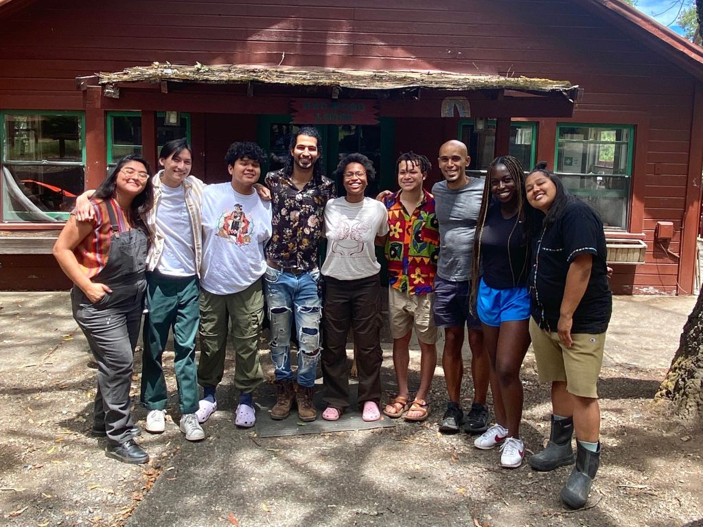 Nine smiling people in front of the Shelterwood Collective.
